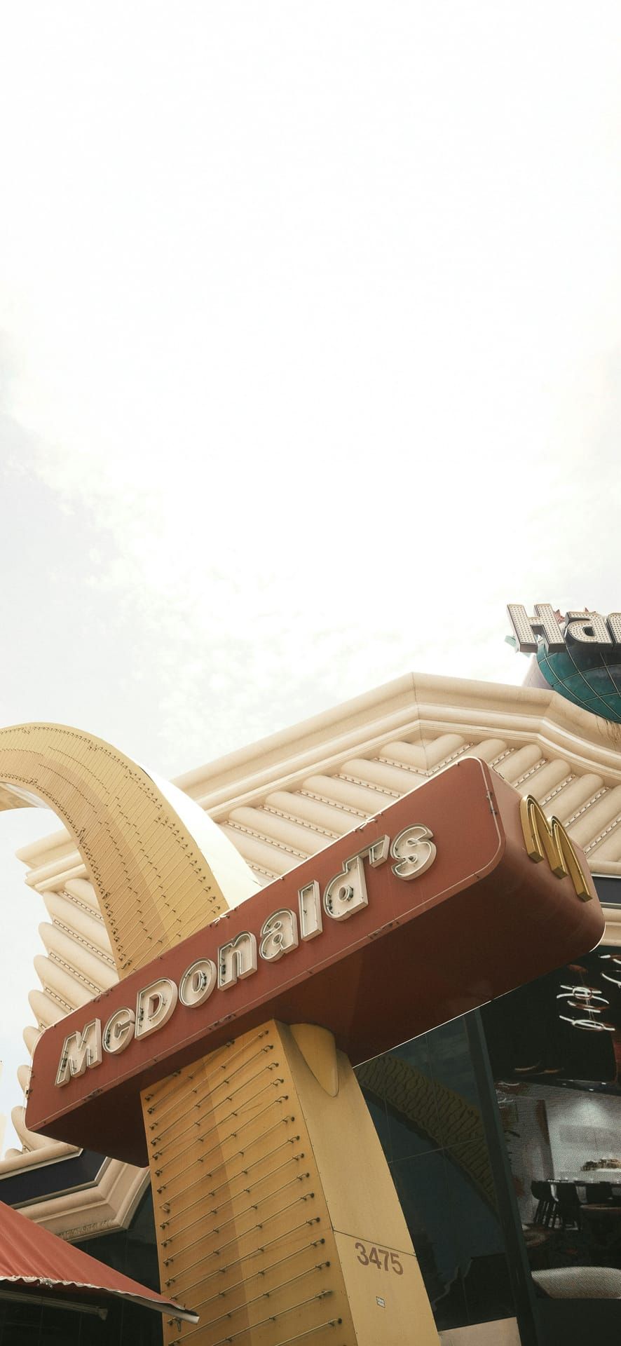 Retro McDonald’s sign with golden arch on Las Vegas Strip, bold vintage design ideal for pop culture-themed Phone Wallpaper.