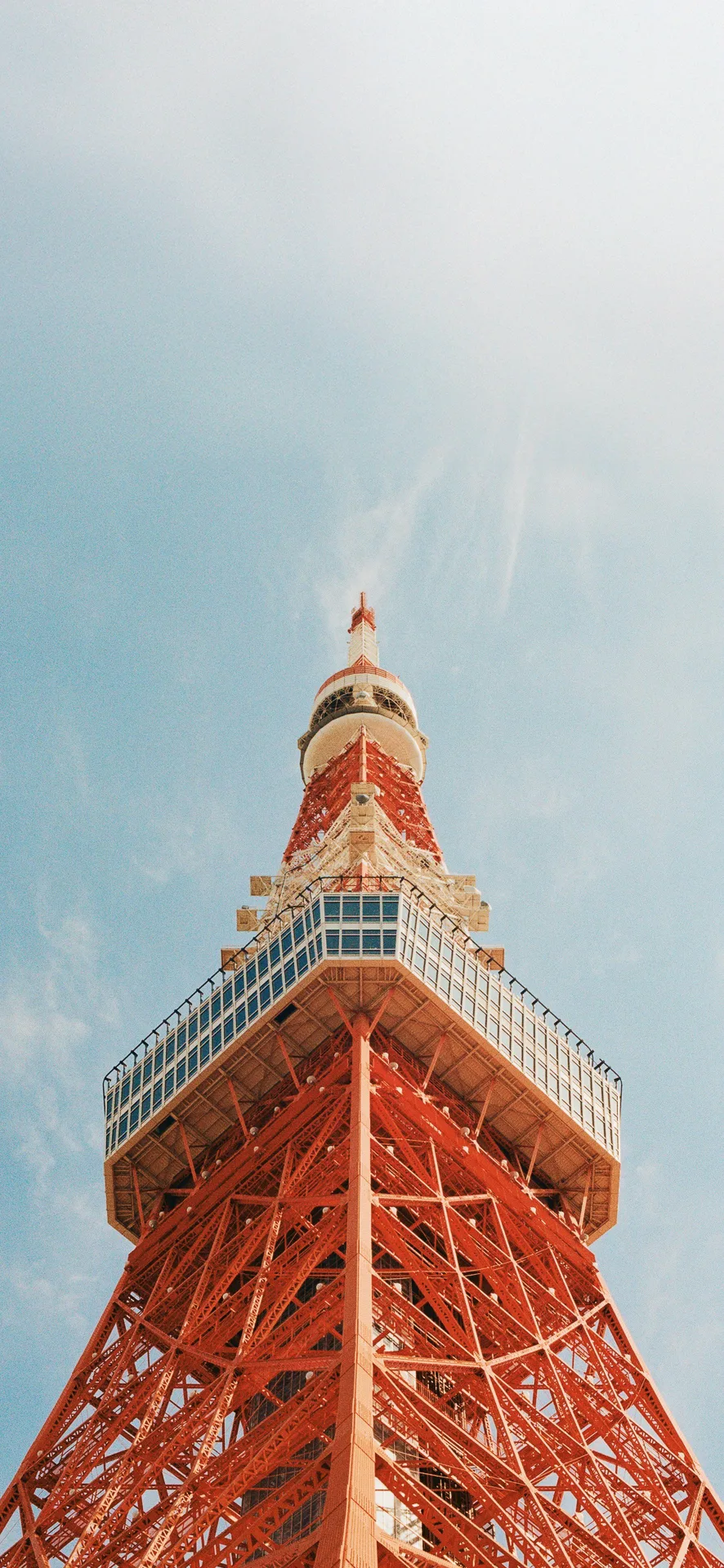 Upward view of Tokyo Tower’s red steel structure against a blue sky in Japan—ideal for urban and travel-themed Phone Wallpaper.